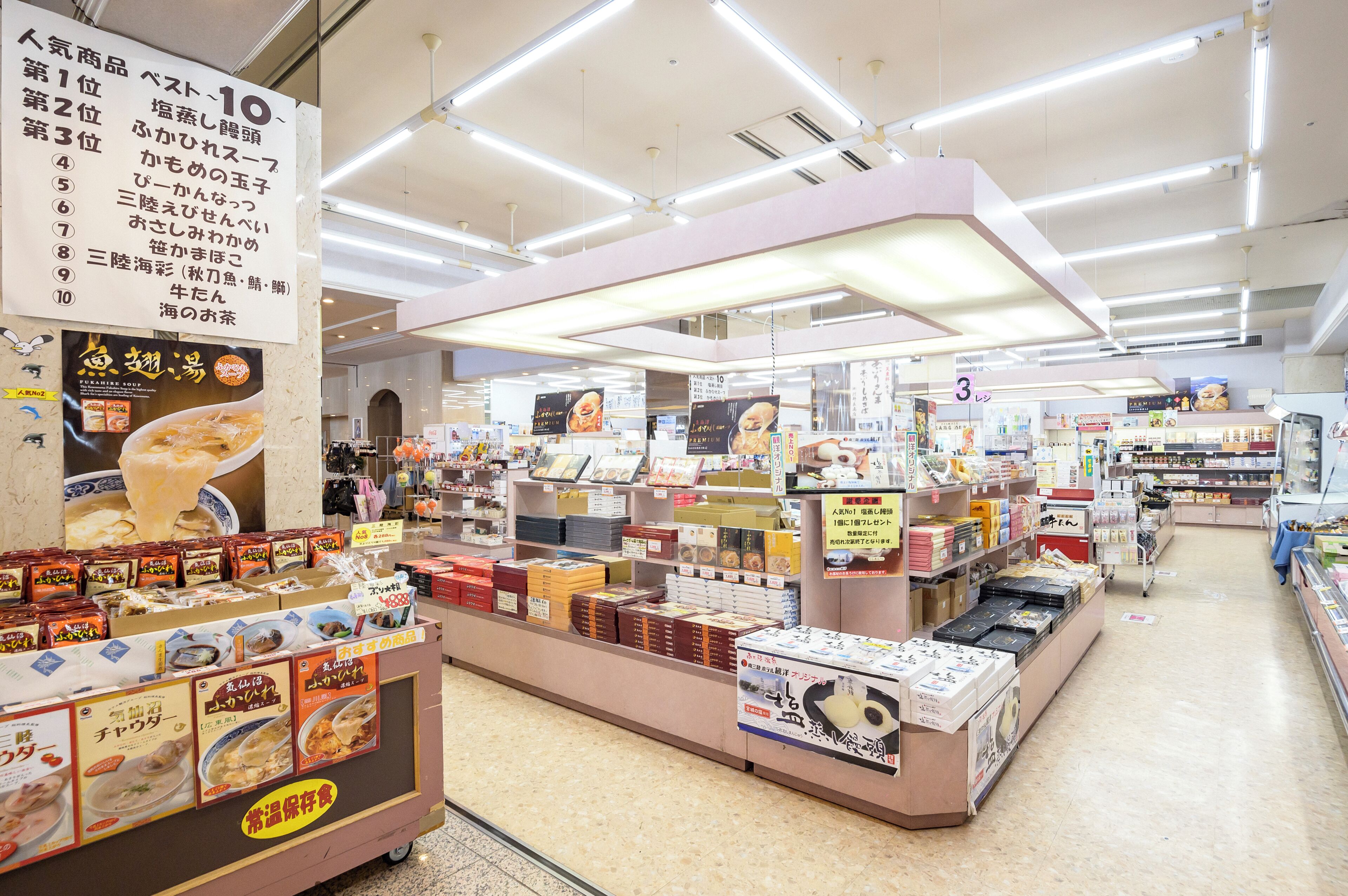 A brightly lit supermarket interior with various food products and promotional signs.