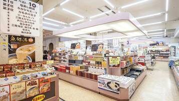 A brightly lit supermarket interior with various food products and promotional signs.