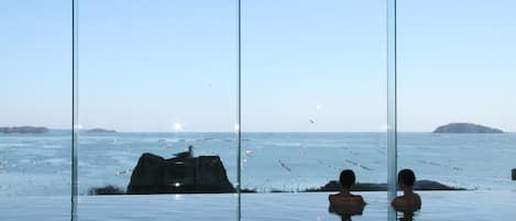 An infinity pool with a clear view of the ocean and distant islands.