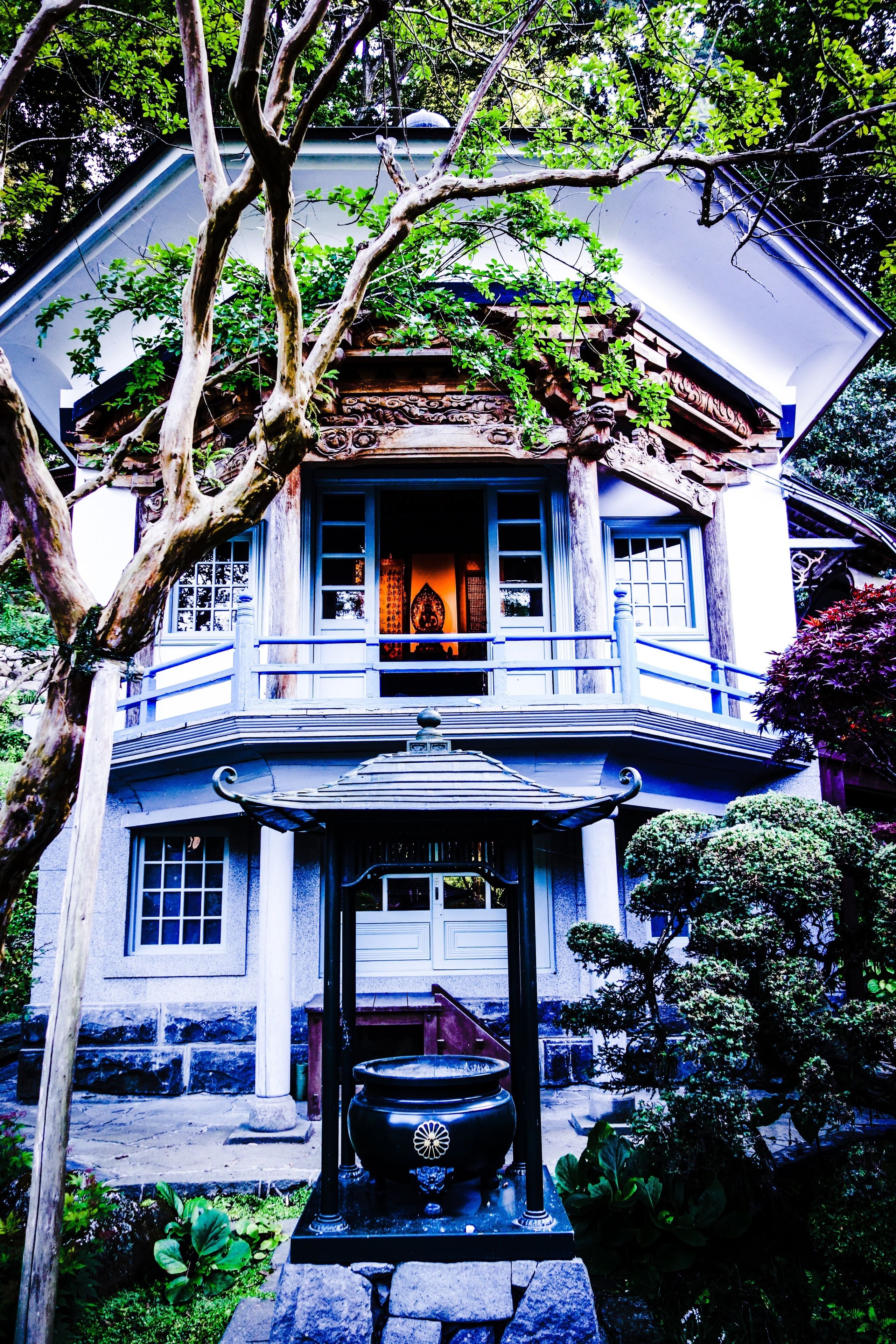 Un edificio tradicional con un balcón, una entrada decorativa y un jardín.