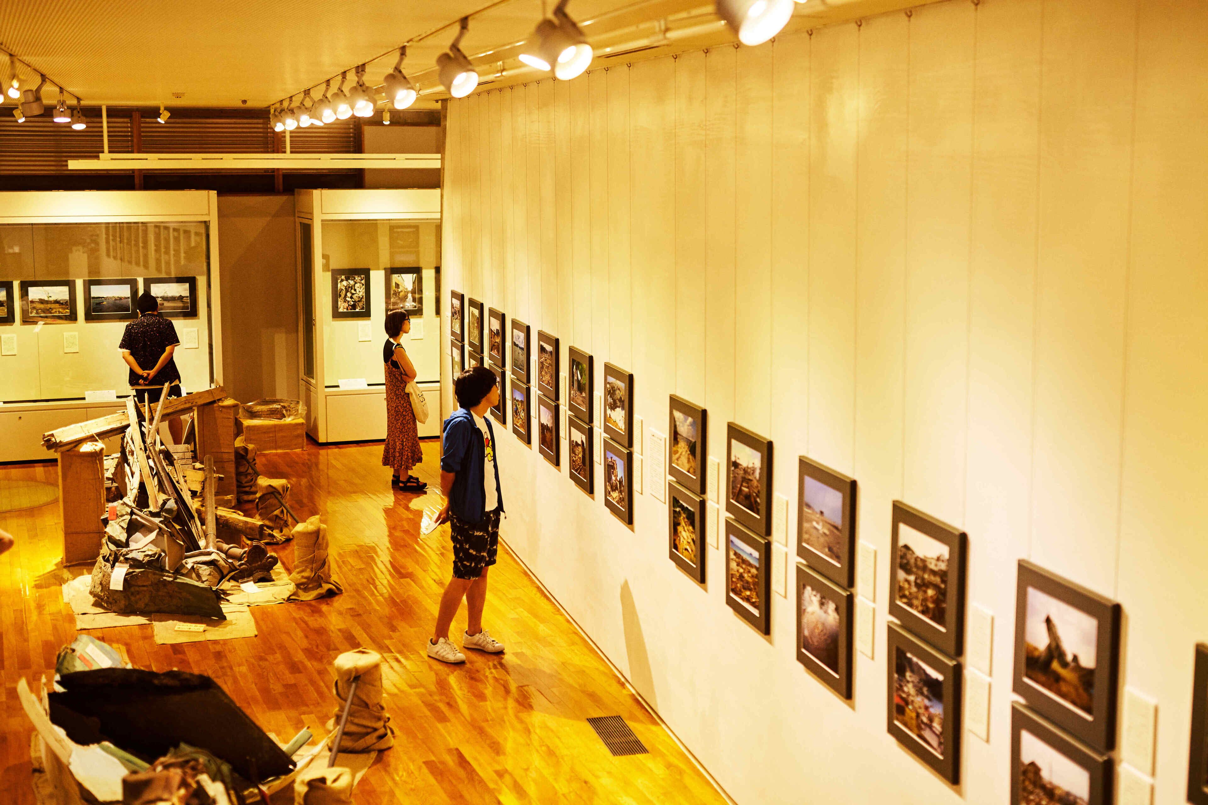 An art gallery with wooden floors and framed pictures on the walls.