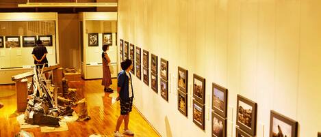 An art gallery with wooden floors and framed pictures on the walls.