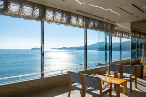 Comedor con amplios ventanales que dan a un cuerpo de agua y tierra distante.