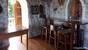 Un interior rústico de piedra con muebles de madera, una chimenea de piedra y una zona de bar de madera.