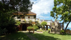 Un edificio histórico con fachada de piedra, un arco central y una escalera que lleva a un balcón.