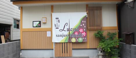 A building with a wooden door and a banner with text.