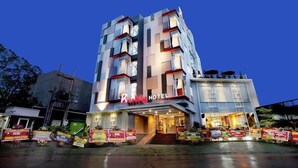 Ein modernes Hotel mit einer auffälligen Schilderung, mehreren Balkonen und einem gut beleuchteten Eingang.