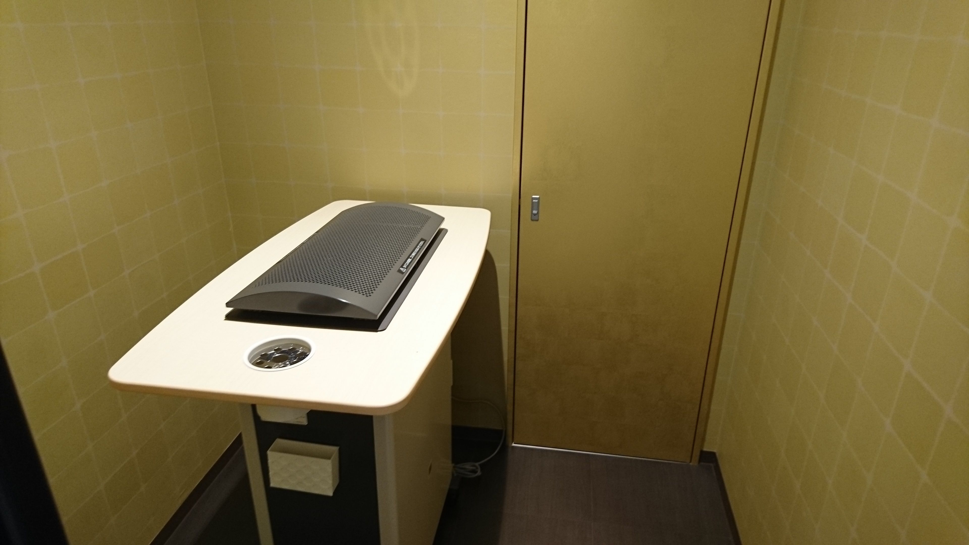 Een kleine, afgesloten ruimte met een medisch onderzoekstoestel, een wastafel en een kast.