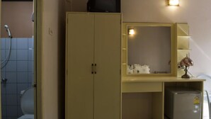 A bathroom with a toilet, a sink, a mirror, and a cabinet. - Lost Resort (Rayong)