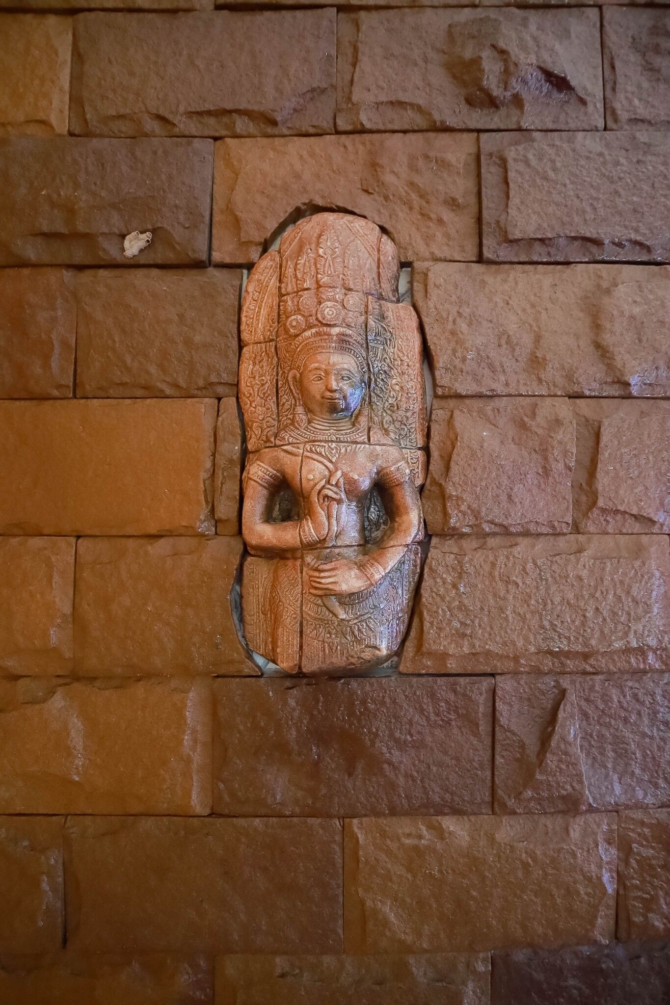 A stone wall with a carved figure.