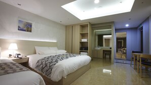 Ein Hotelzimmer mit einem großen Bett, einem Schreibtisch, einem Stuhl, einem Kleiderschrank und einem sichtbaren Badezimmer durch eine offene Tür.