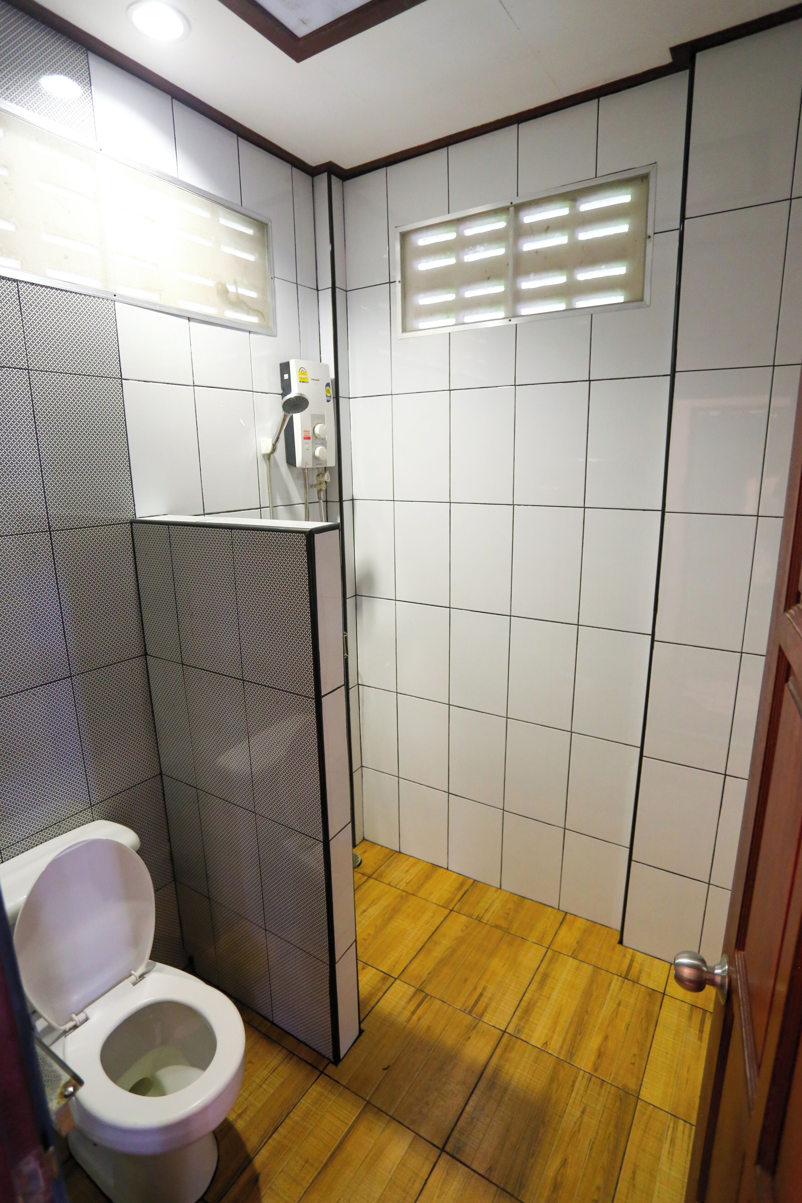 A bathroom with a toilet, a shower area, and a sink.