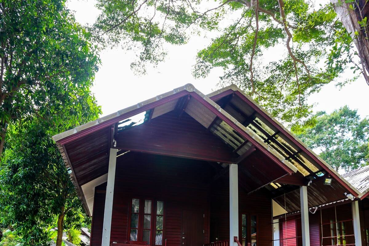 A wooden house with a porch and steps leading to the entrance.