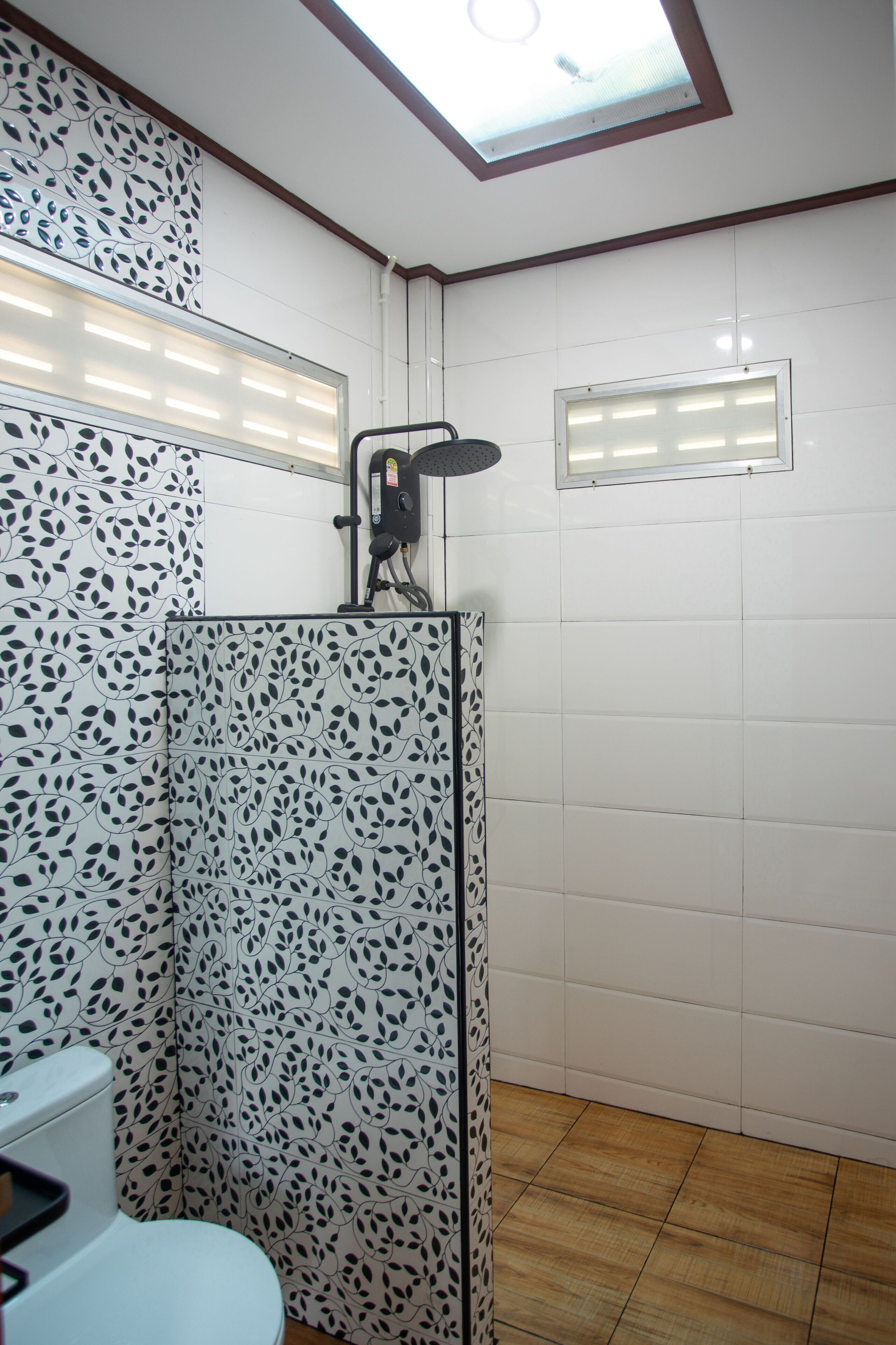 A bathroom with patterned tiles, a shower, and a toilet.