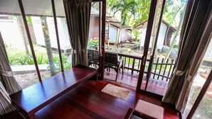 A room with a wooden floor, a bench, and a table. - Tubtim Resort (Rayong)