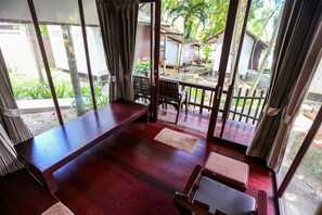 A room with a wooden floor, a bench, and a table. - Tubtim Resort (Rayong)