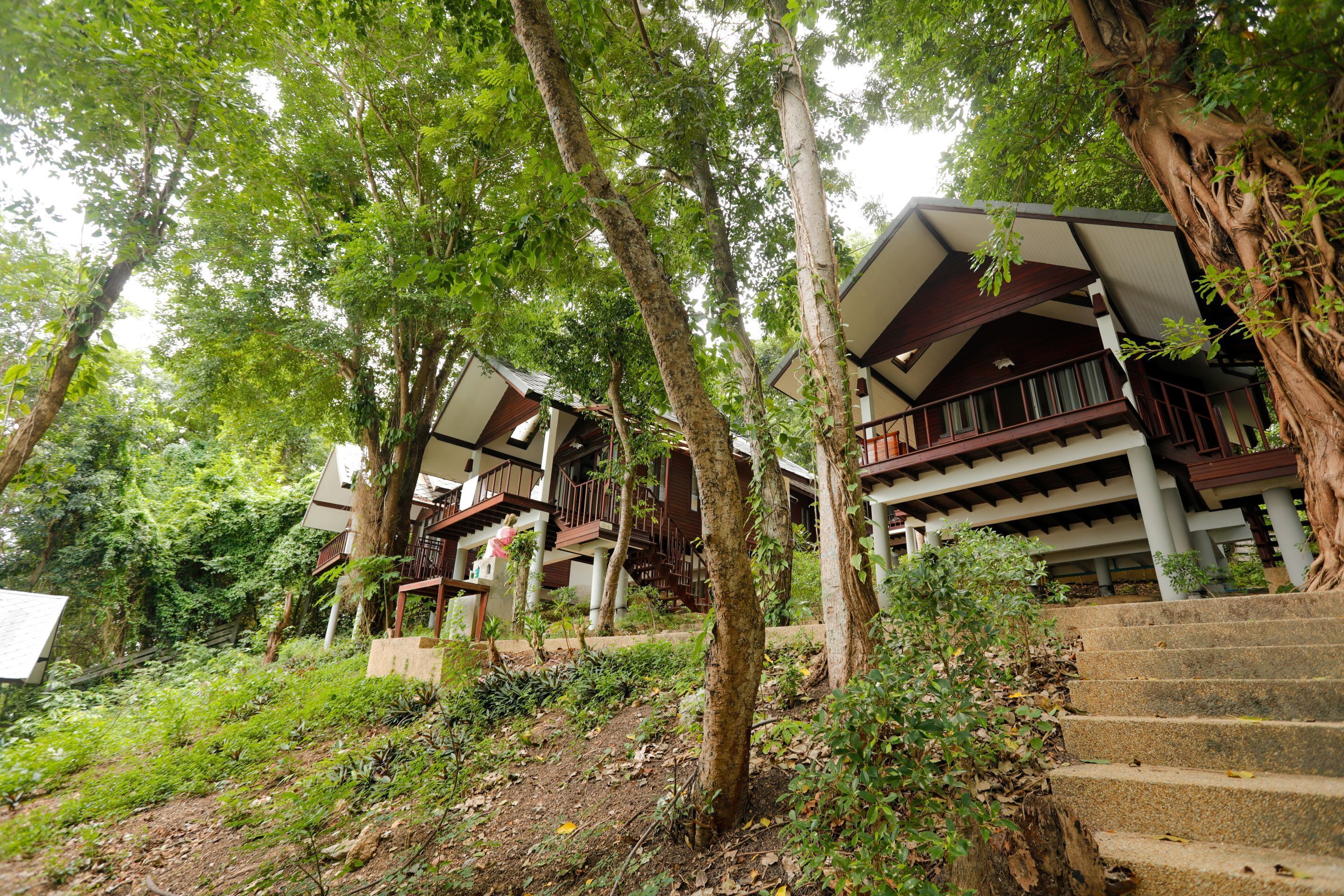 Ein Resort mit mehrstöckigen Gebäuden, Außenstaircases und üppiger Vegetation.