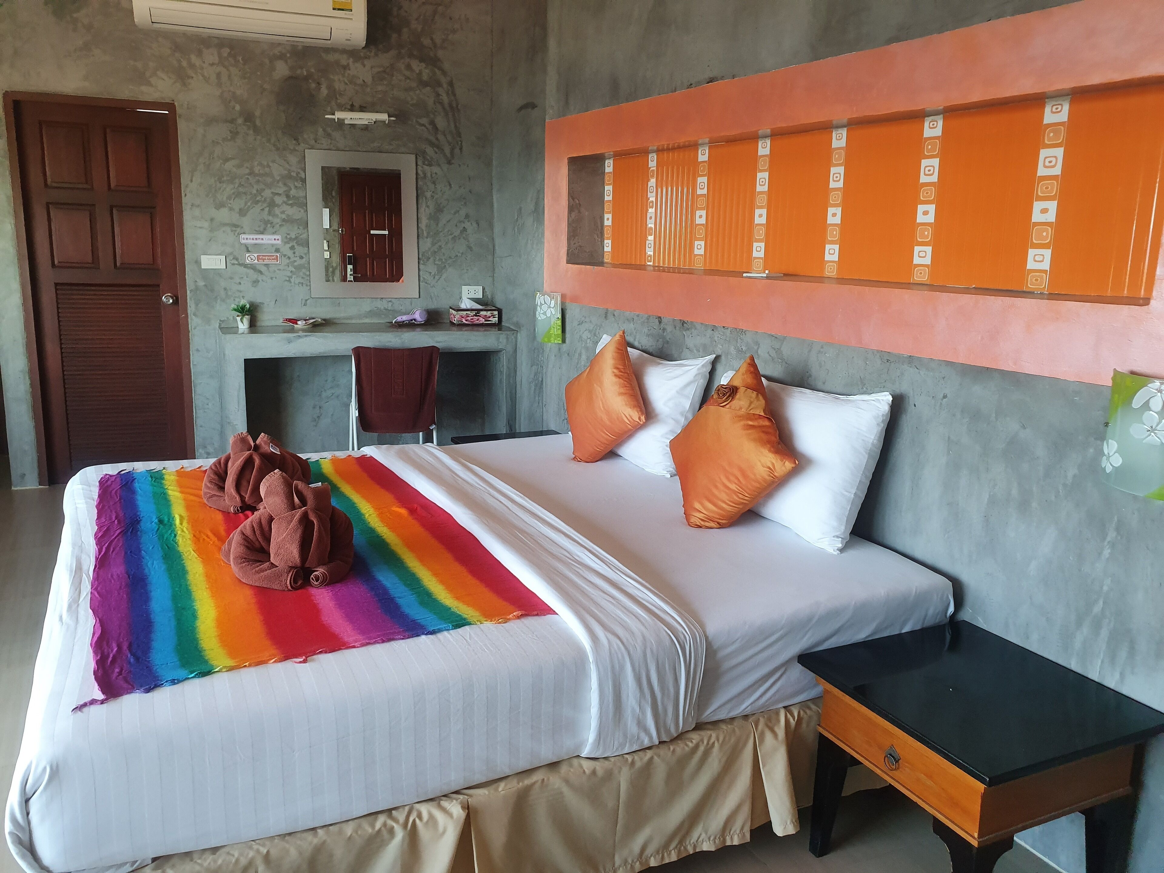 A hotel room with a bed, a desk, and a nightstand.