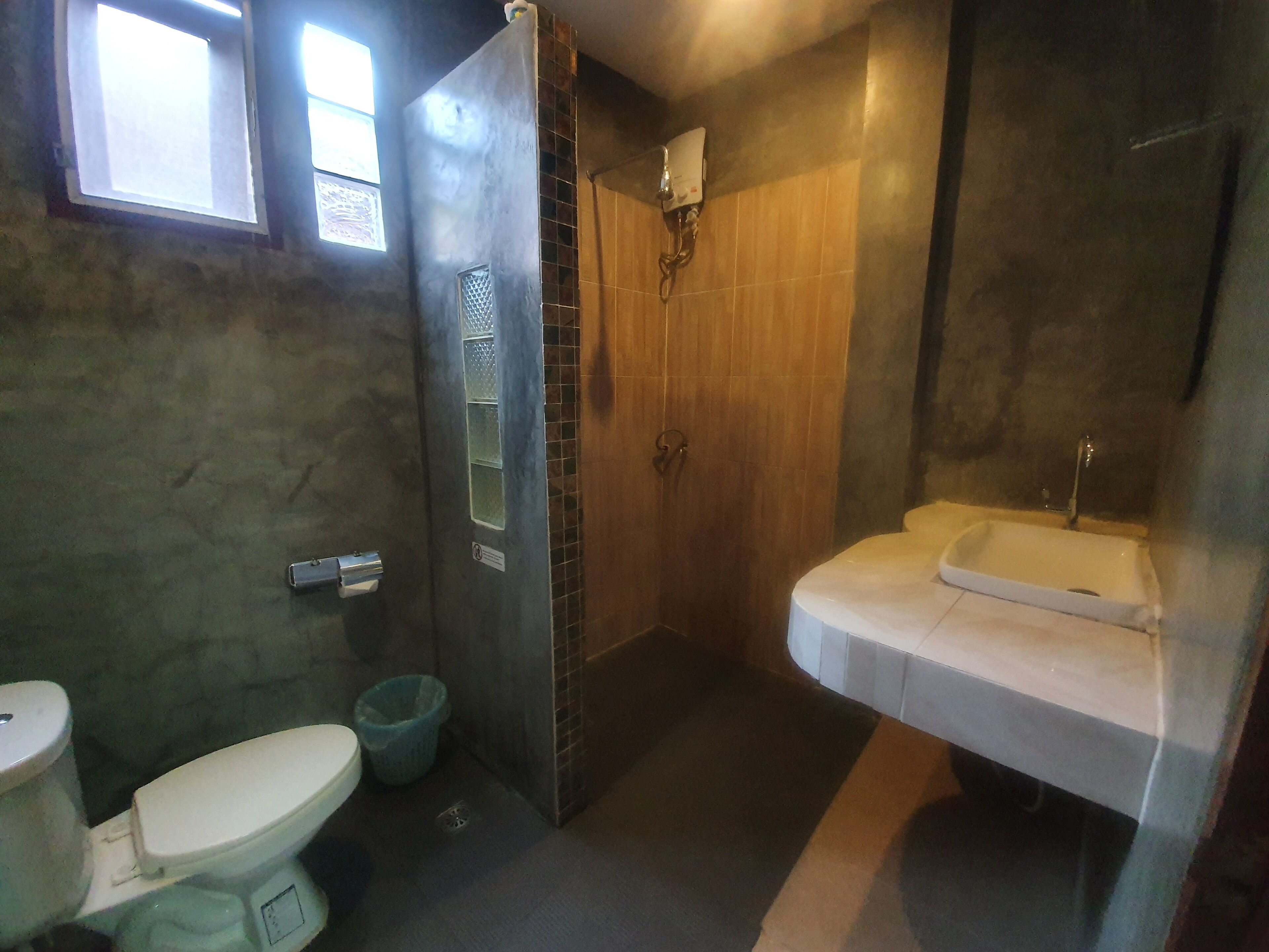 A bathroom with a toilet, a shower, and a sink.