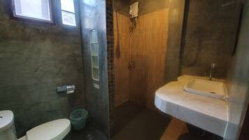 A bathroom with a toilet, a shower, and a sink.