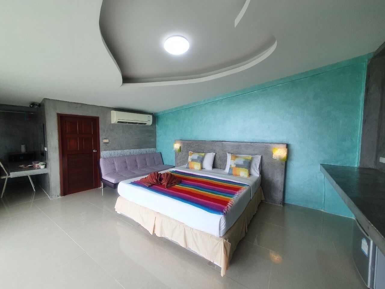A bedroom with a bed, a desk, and a chair.