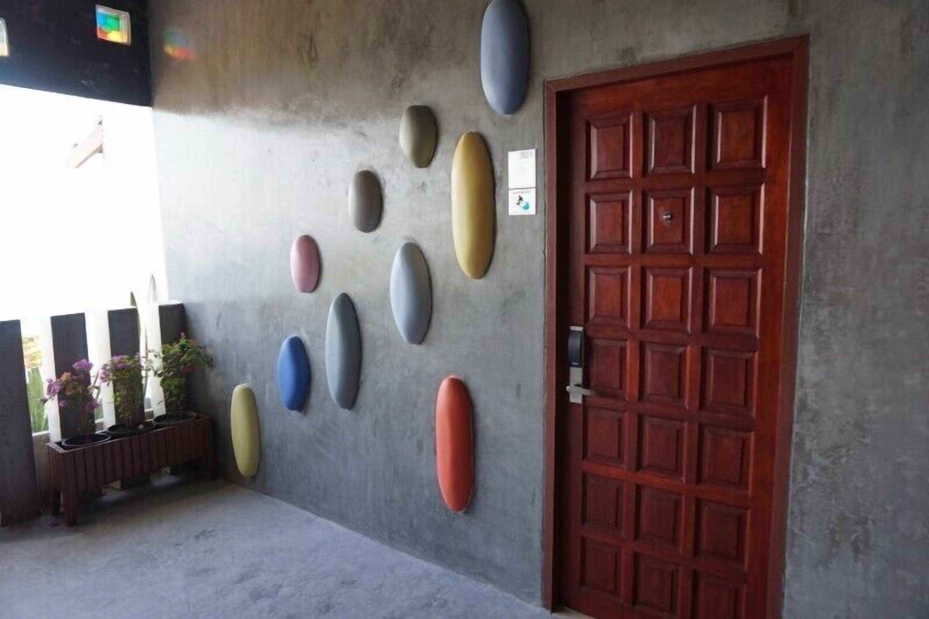 A concrete wall with several oval-shaped objects and a wooden door.