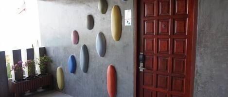 A concrete wall with several oval-shaped objects and a wooden door.