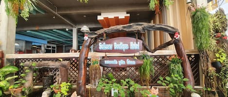 Step into the charming entrance of Saikaew Boutique Hotel, where lush greenery and decorative accents create a warm welcome.