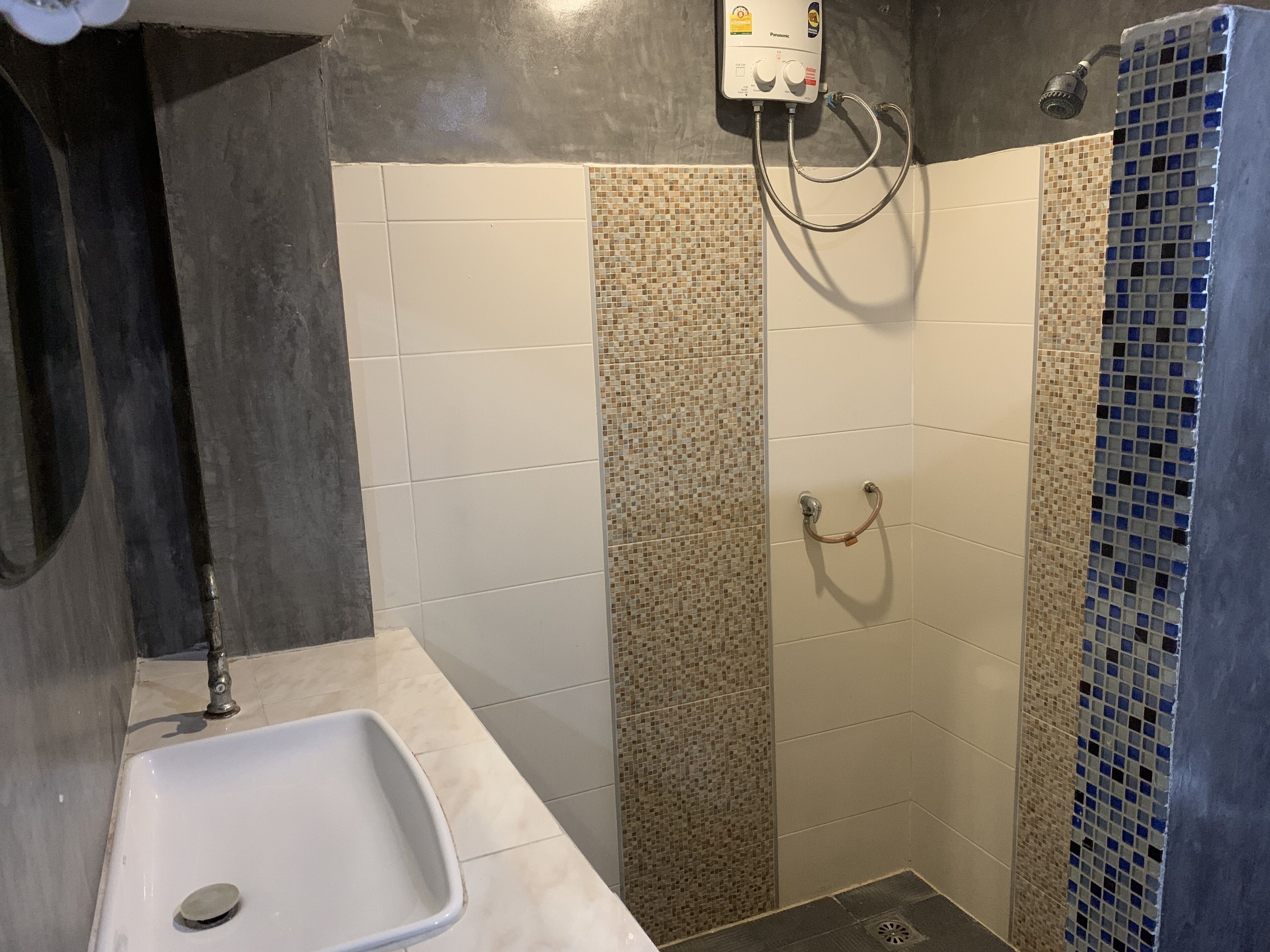 A bathroom with a shower, a sink, and a toilet.