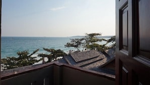 Blick vom Balkon auf ein Gewässer mit weiter Küste.