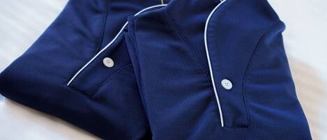 Two neatly folded navy blue shirts with white piping and buttons.
