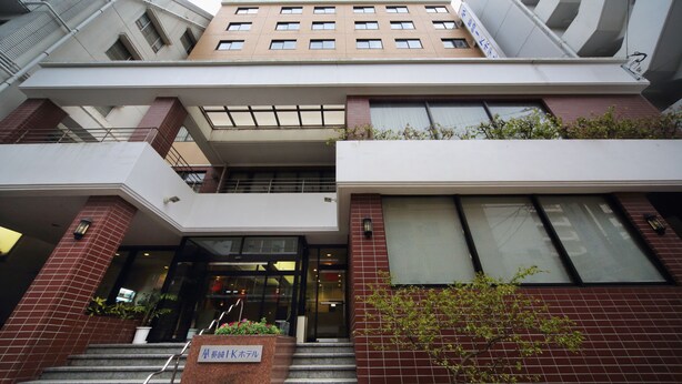 A multi-story building with a modern architectural design, featuring a mix of brick and glass facades, and a prominent entrance with steps leading up to it. - Nagasaki IK Hotel (Nagasaki)