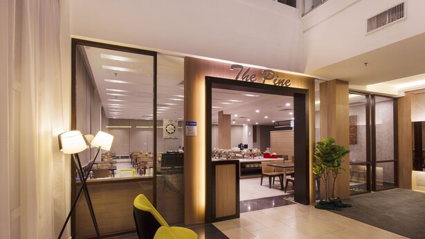 Un moderno vestíbulo de hotel con mostrador de recepción, zona de estar y comedor.