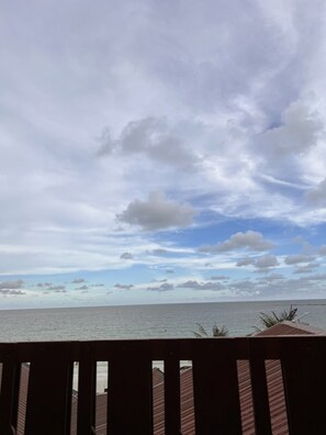 A wooden deck overlooking a calm sea with a partly cloudy sky. - Jirawan Hotel (Rayong)