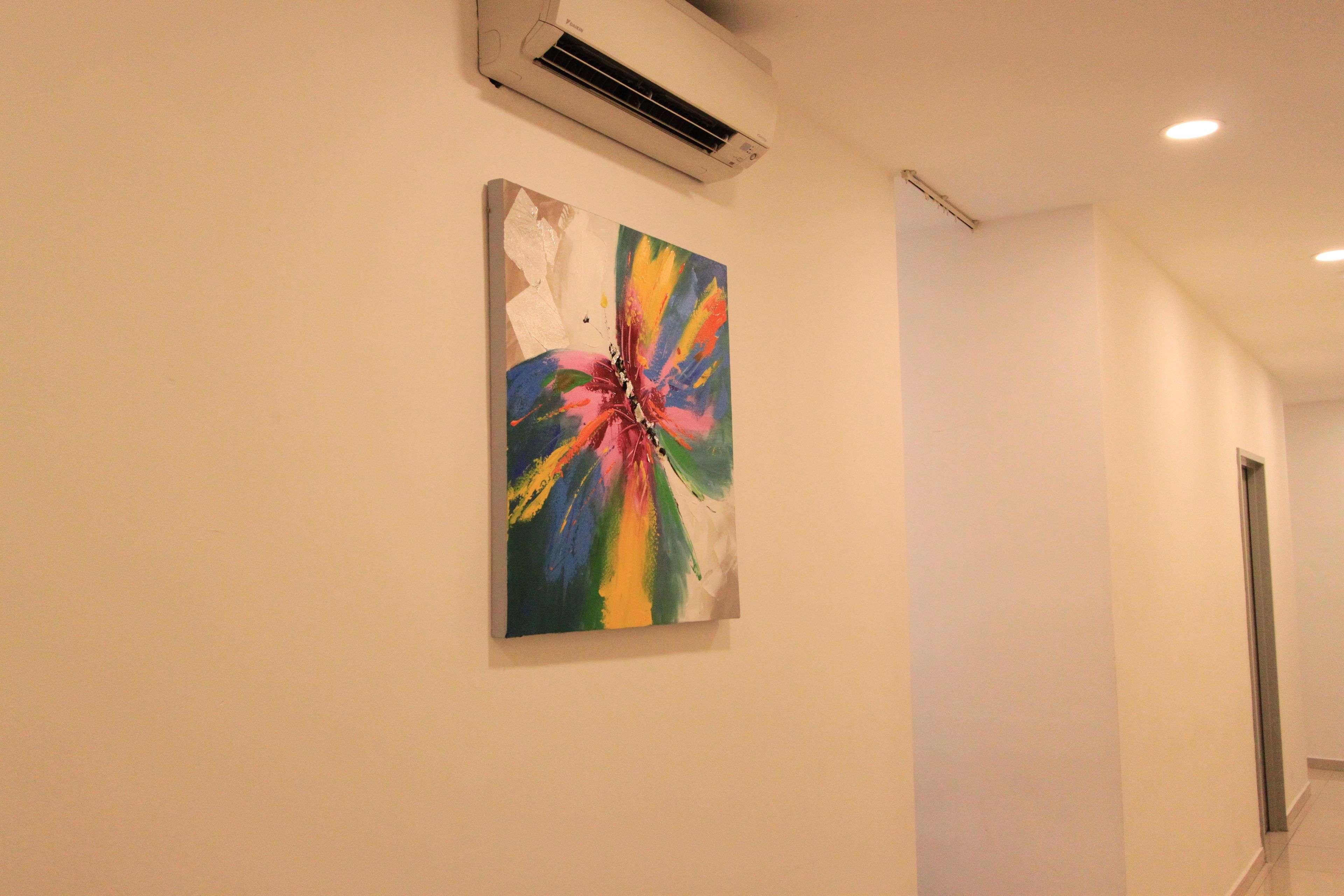 Ein Flur mit einem farbenfrohen, abstrakten Gemälde an der Wand und einer Klimaanlage darüber.