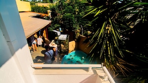 A rooftop pool area with people around, a small pool, and surrounding greenery. - Solano Hotel (Hersonissos)