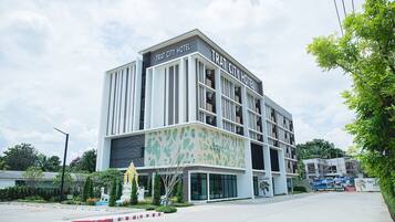 A modern hotel with a flat roof, large windows, and a sign reading "TRAT CITY HOTEL".
