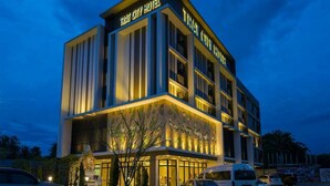 Un hotel a più piani con una facciata moderna, ampie finestre e un ingresso ben illuminato.
