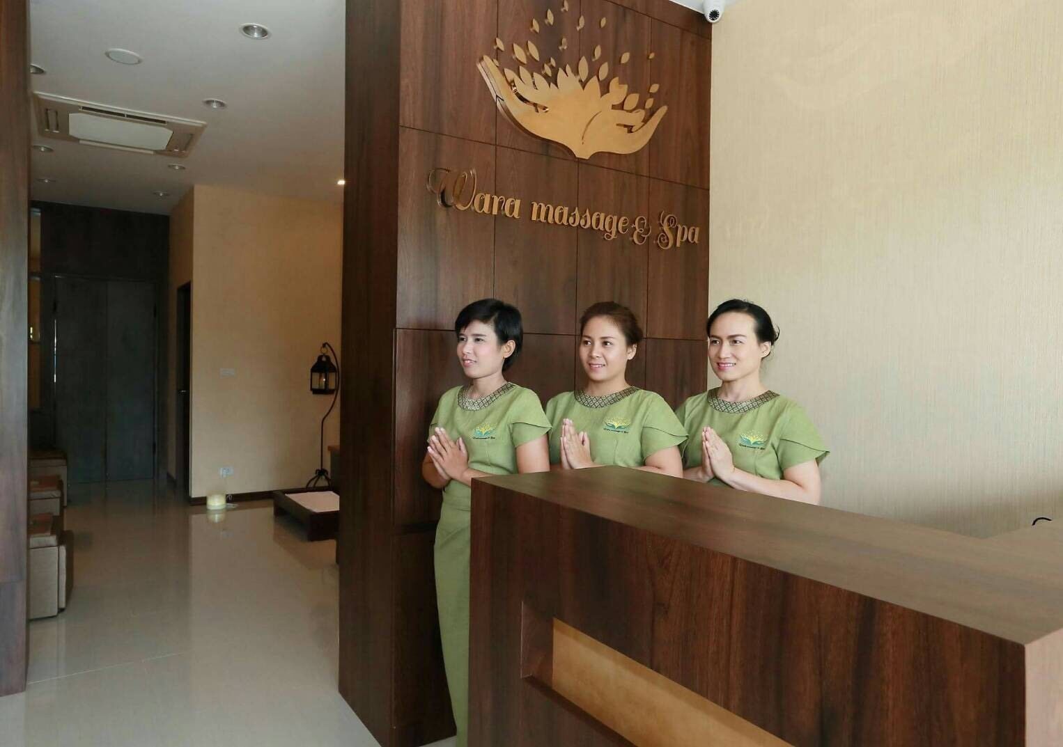 Un mostrador de recepción con un panel de madera y un logo en la parte superior.