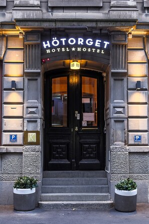 The entrance to Hötorget Hotel/Hostel with a black double door, steps leading up to it, and two potted plants on either side. - Hotel Hotorget, BW Signature Collection (Stockholm)