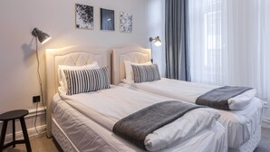A hotel room with two beds, a standing lamp, and a small stool. - Hotel Hotorget, BW Signature Collection (Stockholm)