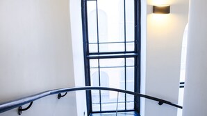 A spiral staircase with a black handrail and a window at the top. - Hotel Hotorget, BW Signature Collection (Stockholm)