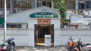 A building with a sign reading "Hotel Evergreen 1946" and "KOSMIC" on the entrance. - Evergreen Hotel (Mumbai)