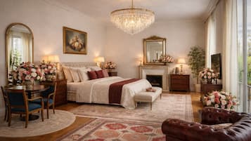 A bedroom with a large bed, a chandelier, a fireplace, and a view of the outdoors.