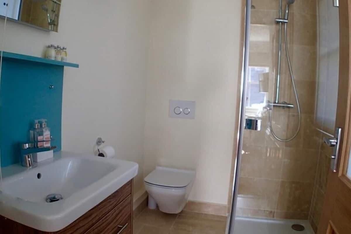A bathroom with a sink, toilet, and shower.