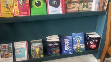 Uma estante com diversos livros, incluindo títulos como 'The Korean Sensation' e 'Bookstore Girls'.