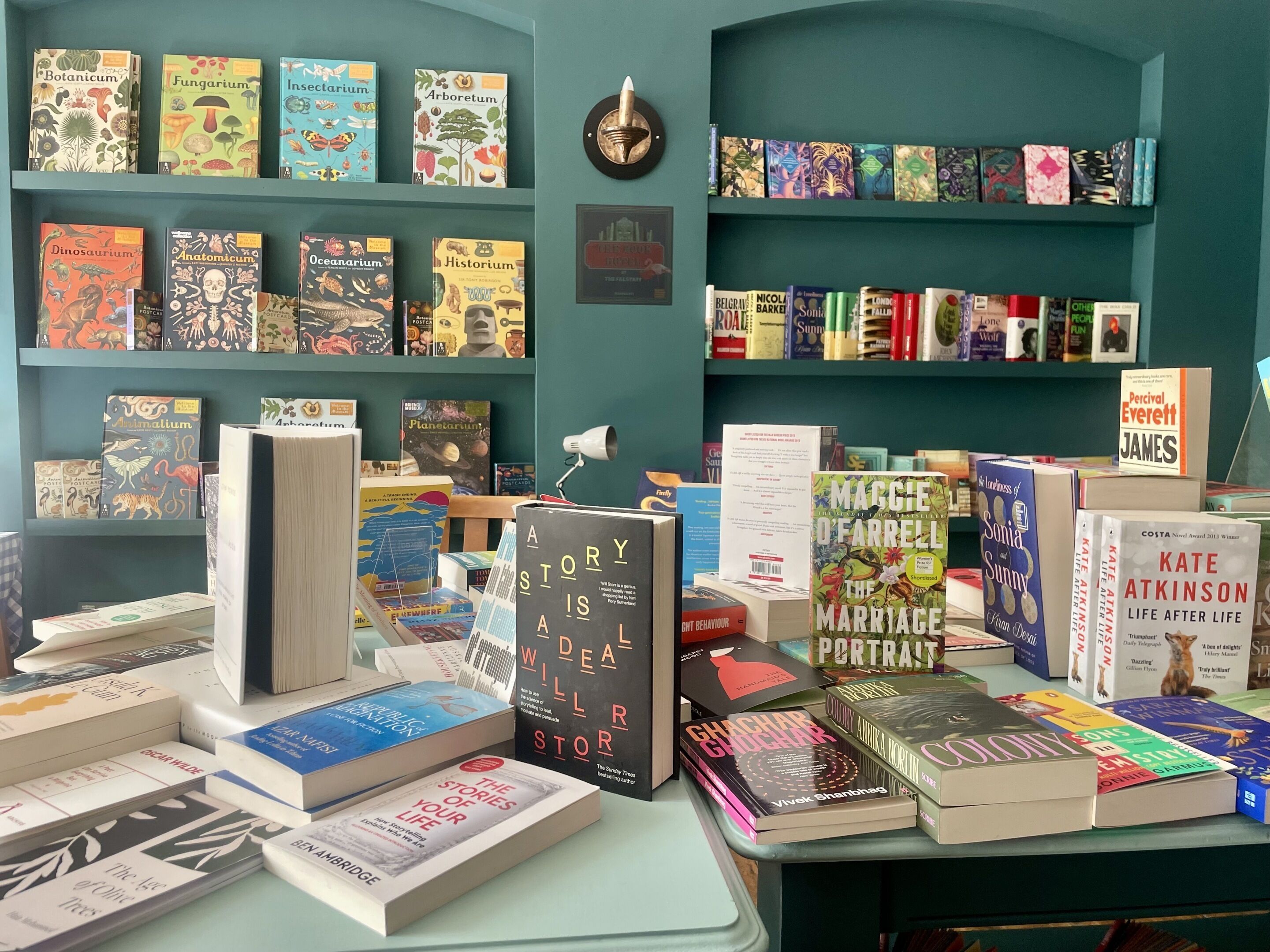 A book display with various titles and a clock on the wall.