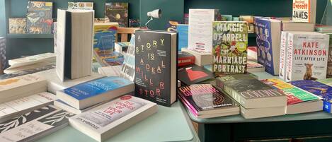 A book display with various titles and a clock on the wall.