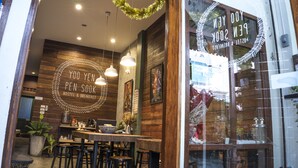 Een gezellig café interieur met houten wanden, hangende lampen en een goed zichtbaar menubord.