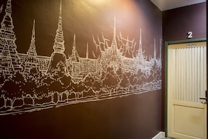 A wall mural of a temple complex with a door labeled "Lady dorm" and the number "2" above it.